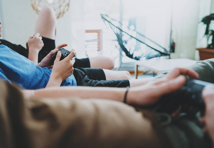 友谊, 技术, 游戏和放松的时间在家里的概念关闭男性朋友在客厅玩电子游戏