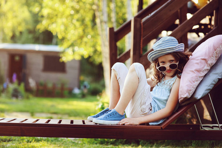 不愉快的孩子女孩放松在日光浴在夏天庭院在假期