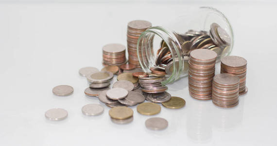 玻璃罐在白色背景上用硬币存钱