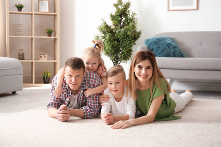幸福的家庭躺在舒适的地毯在家里