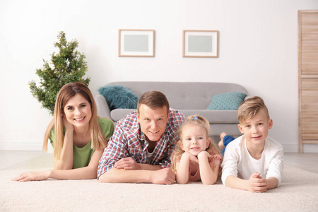幸福的家庭躺在舒适的地毯在家里
