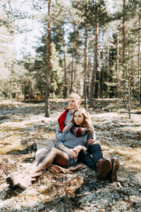 婚前照片拍摄在森林中的自然, 以步行和旅游的形式。北方和俄罗斯的美丽。爱的人和美丽的风景。他们笑着, 坐着, 微笑着。美丽的情侣