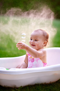 漂亮的小女孩，在夏天洗澡用肥皂泡