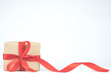 包装手工工艺纸棕色礼品盒与红丝带弓孤立的白色背景。圣诞, 新年, 生日快乐现在复古色调的装饰理念