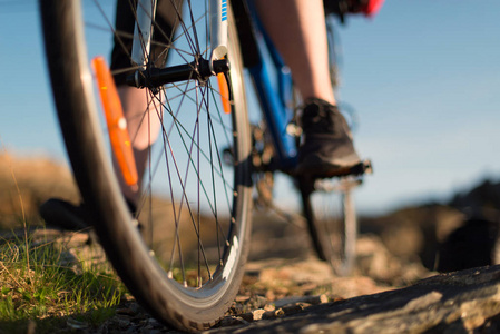 在日出的路上, 骑山地自行车的骑车人的低角度观看。体育和活跃生活概念