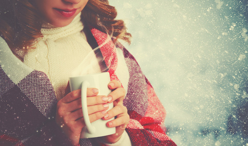 幸福的女人，在寒冷的冬天户外杯热饮杯