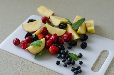 切片新鲜的苹果, 蓝莓, 草莓, 黑莓和薄荷叶周围, 新鲜的夏季水果