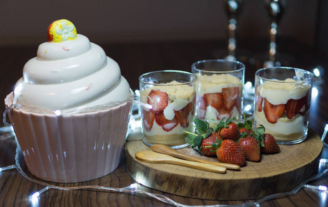 玉兰甜点用木盘子配上草莓。饰以轻和蛋糕杯子