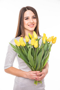 幸福的女人，穿着与孤立的白色背景上的黄色郁金香