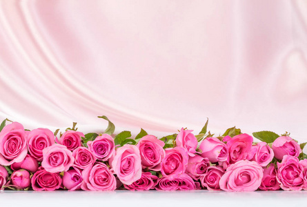 软白色真丝织物上的花束甜粉红玫瑰花瓣
