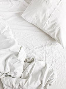 平躺在白色的床上, 枕头, 毯子和床单。最高视图最小亚麻概念