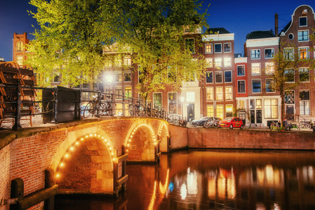 晚上在阿姆斯特丹运河。突出显示的建筑和街道