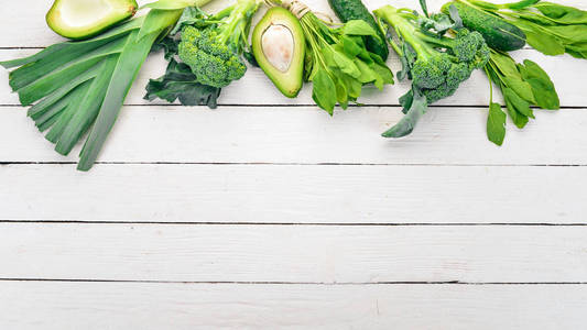绿色蔬菜和水果。在白色的木质背景。健康食品。顶部视图。复制空间