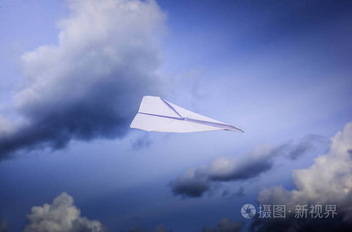 纸飞机在天空中飞翔在云层中.假期和自由 而纸飞机在风中轻飞