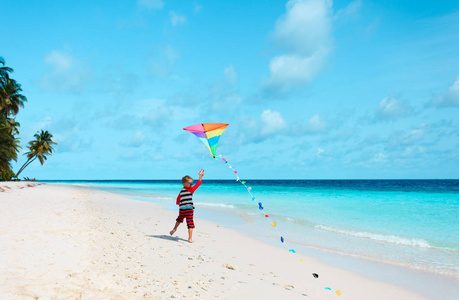 在热带的海滩上放风筝的小男孩