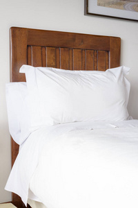 木制床和枕头和白色的亚麻布床单
