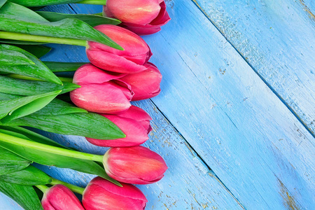 蓝色木桌上的郁金香花束。快乐的妇女节。3月8日, 母亲节。平面放置和复制空间