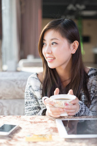 年轻漂亮的中国女人在咖啡馆
