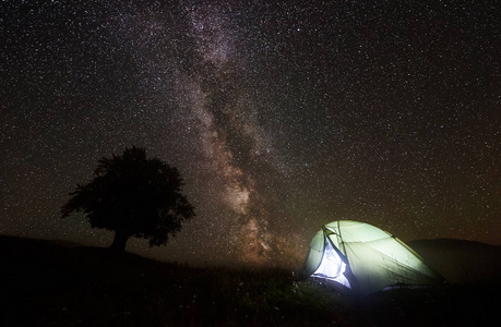 令人难以置信的夜景, 照亮的旅游帐篷露营在山谷和大树对深黑的天空与 milliards 闪闪发光的星星和银河。旅游业和旅游概念