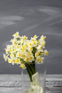 白色的水仙。春天的花朵复古的桌子上。时尚的办公室。报名的地方。碑文的地方。鲜花插在花瓶里