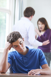 不开心的十几岁的男孩与父母吵架的背景