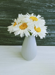 木制背景花瓶的菊花花束