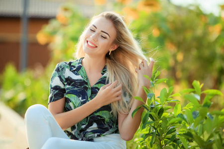 年轻美丽的金发女人的肖像, 背景向日葵