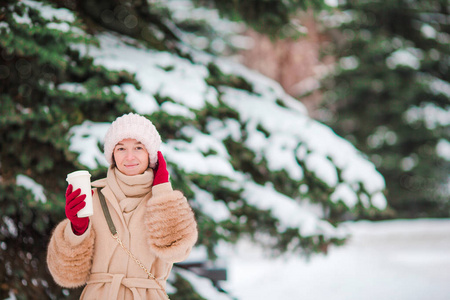 咖啡在美丽的冬天下雪天去户外的漂亮女孩