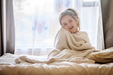 年轻的孩子女孩裹着毯子的室内肖像