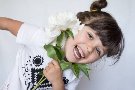 快乐和快乐的4或5岁的孩子笑着看着相机。小女孩捧花