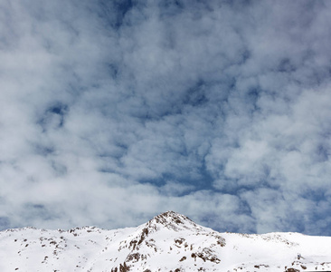 多云天空背景下的雪山山峰