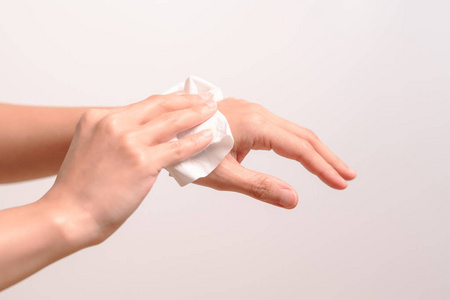 妇女用白色软组织纸清洁双手。在白色背景上被隔离