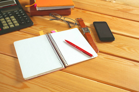 表面的一张小木桌与笔记本 智能手机 眼镜 钢笔