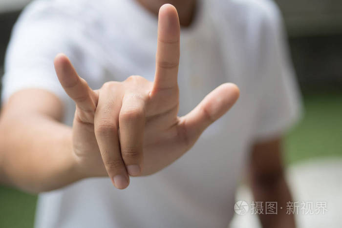 男人用爱或摇滚的手势;亚洲男子展示爱牌或摇滚手牌;亚洲青年成年男子
