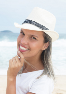 戴着帽子在海滩白人女子肖像