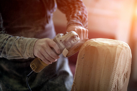 一个木匠的特写, 建筑工人在工作服锯从木一个人的头切割出雕塑, 用一个角磨床在车间, 在许多工具, 木, 家具为工作