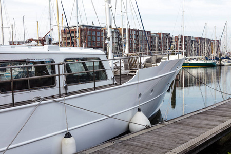 荷兰海牙斯海弗宁恩的港口停泊着许多白色帆船。在海港的停靠船与尼斯晴朗的天空和蓝色的海背景