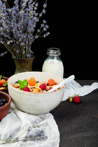 健康素食早餐。燕麦片, 有覆盆子和蓝莓的麦片粥, 棕色背景, 花束薰衣草。顶部视图。平躺