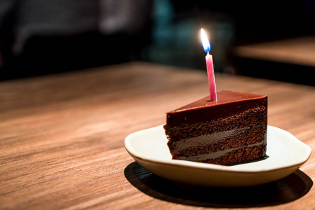 巧克力蛋糕与生日蜡烛在餐馆咖啡馆
