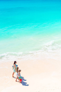 可爱的小女孩和年轻母亲，在白色的沙滩上