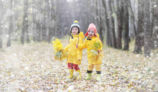 在秋季公园散步的蹒跚学步的孩子。第一霜冻和第一