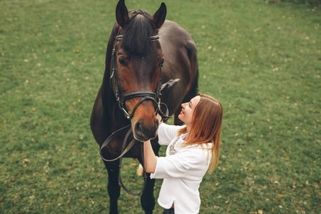 美丽的女孩与一匹马在公园里进行通信