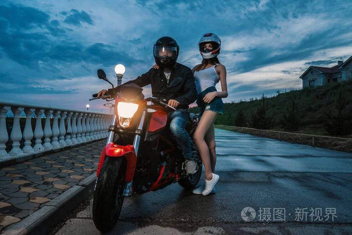 骑自行车的夫妇男人和女人在黑色和红色的运动摩托车
