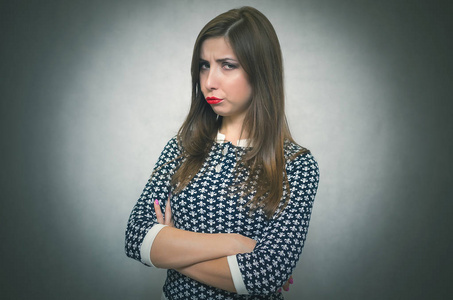 伤心冒犯的女人肖像被孤立在灰色背景上。烦恼。失望的女孩