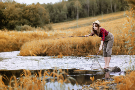 女孩在秋天与钓鱼竿