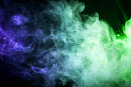 黑色背景上的彩色蓝色和绿色烟雾。从 vap 的烟雾背景