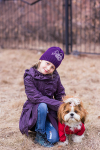 一个可爱的小女孩的肖像与她的宠物狗在户外