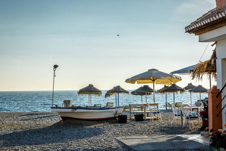 一艘船和椅子和遮阳伞在海滩的视图