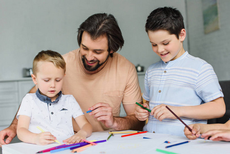 父亲帮助儿子在家里画画用彩色铅笔画的肖像
