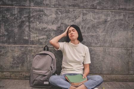 教育理念。漂亮的亚洲女孩在学习上很清楚。对亚洲女性的研究看起来很严肃。亚洲女性因认真学习而头疼。亚洲妇女教育